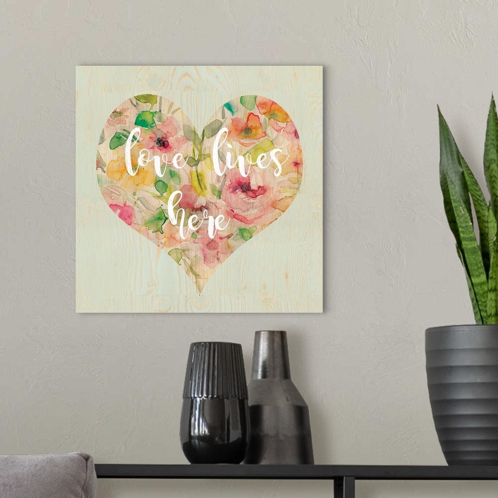 A modern room featuring "Love Lives Here" written in white script inside a heart filled with watercolor flowers, all on a...