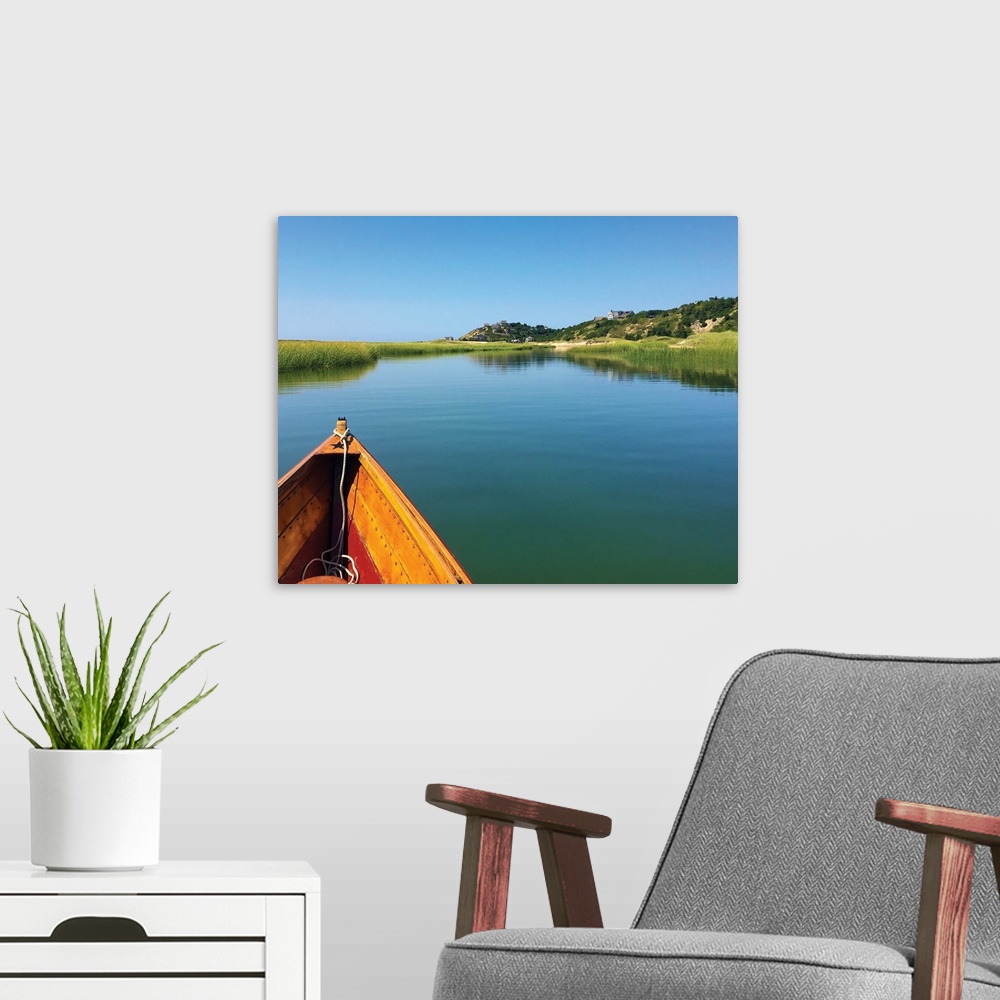 A modern room featuring Photograph of the front of a boat floating down an inlet towards the shore.