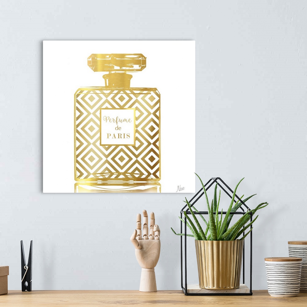 A bohemian room featuring Fashionable square decor with a metallic gold Perfume de Paris bottle on a white background.