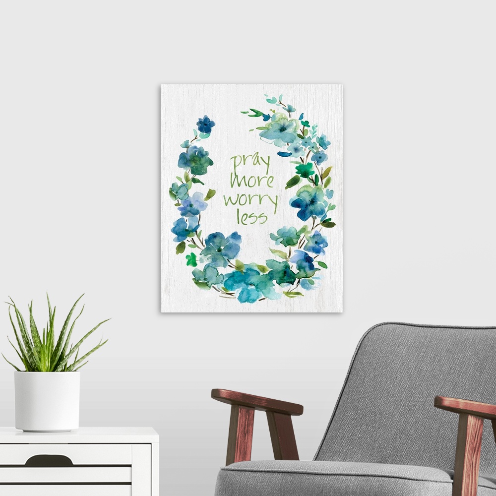 A modern room featuring "Pray More, Worry Less" placed on white textured background with blue flowers surrounding it.