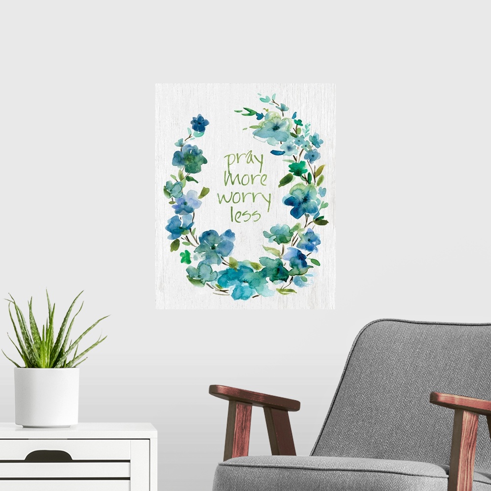 A modern room featuring "Pray More, Worry Less" placed on white textured background with blue flowers surrounding it.