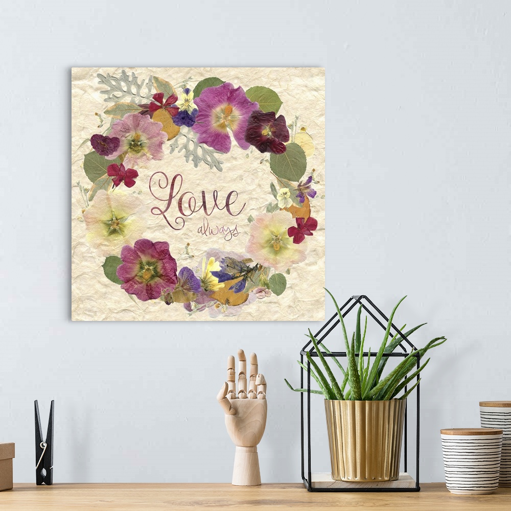 A bohemian room featuring Square art with a wreath made of dried and pressed flowers with the phrase "Love Always" written ...
