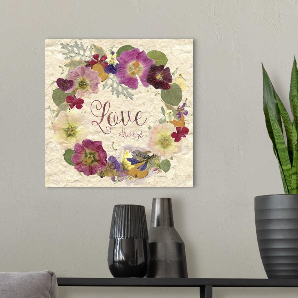 A modern room featuring Square art with a wreath made of dried and pressed flowers with the phrase "Love Always" written ...