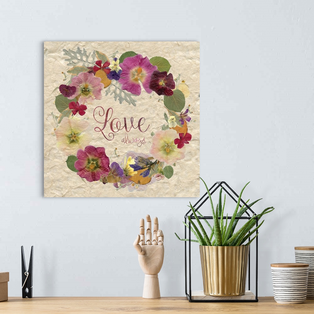 A bohemian room featuring The word "love" in a wreath made of dried, pressed flowers.