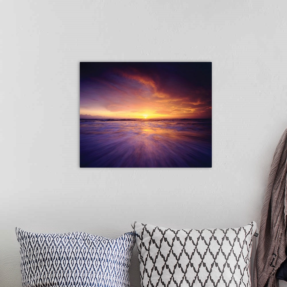 A bohemian room featuring Long exposure photograph of the sun setting on the ocean's horizon in shades of purple, pink, and...