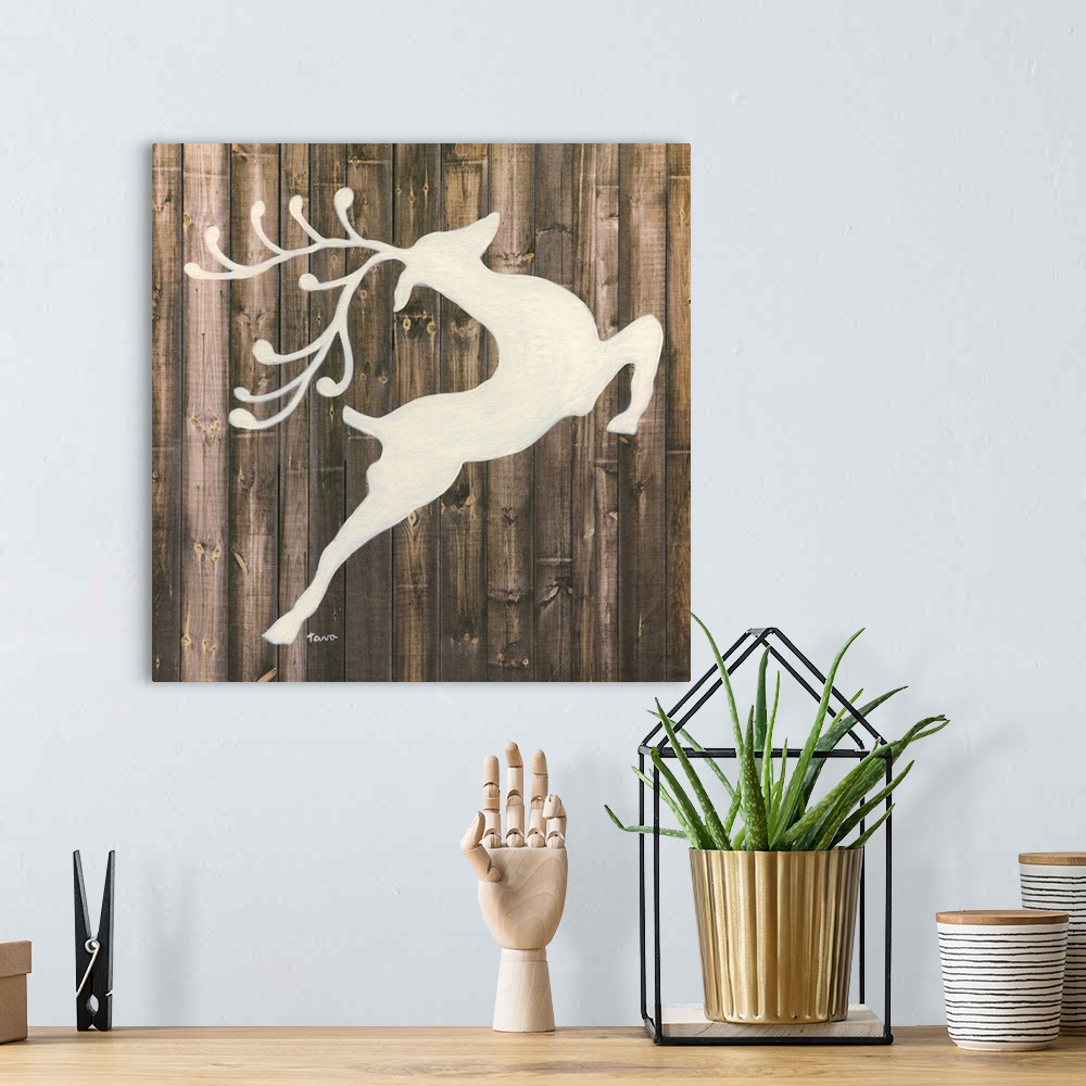 A bohemian room featuring A decorative painting of a white reindeer silhouette on a wood background.