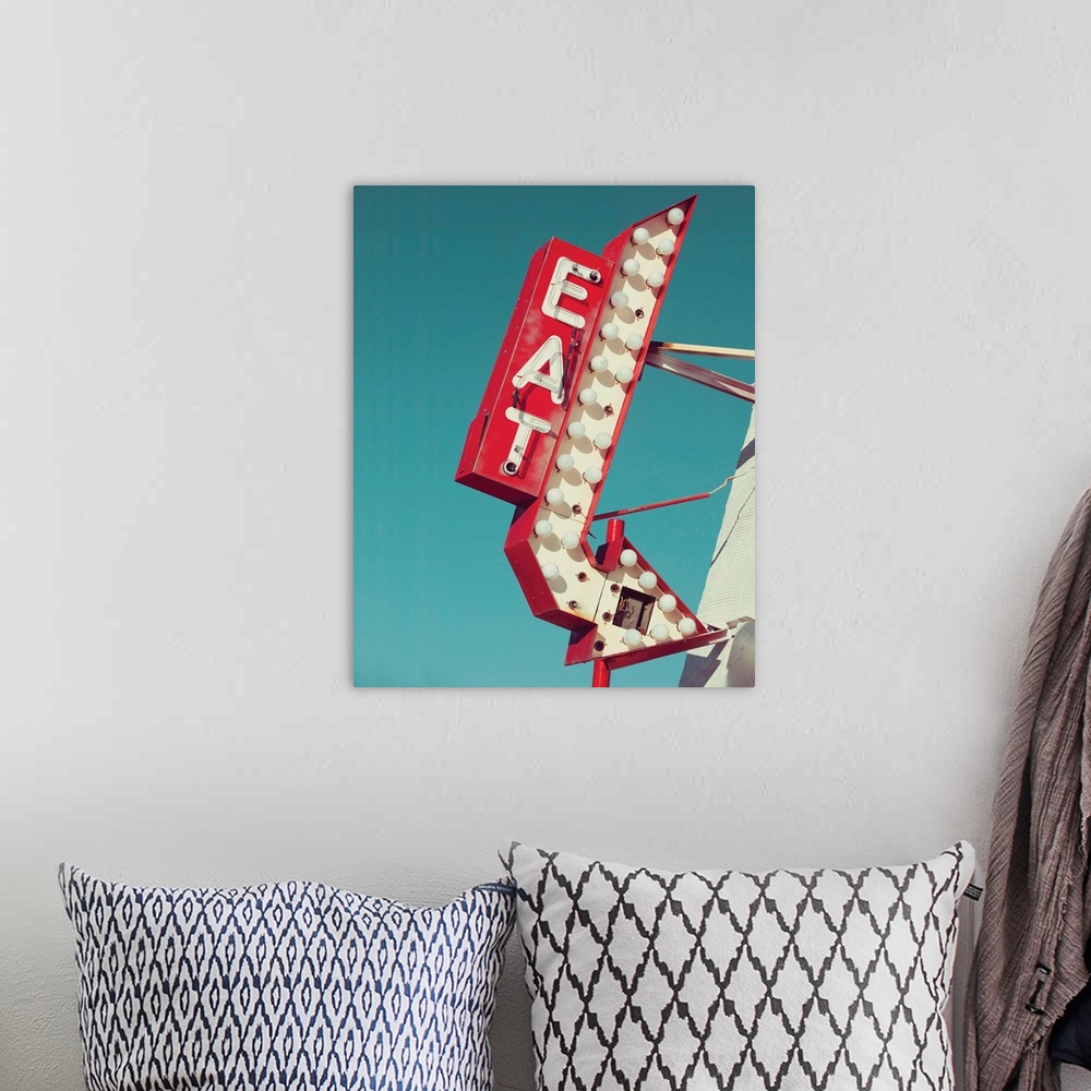A bohemian room featuring Photograph of a vintage red and white light up 'EAT' sign with an arrow on a blue sky background.