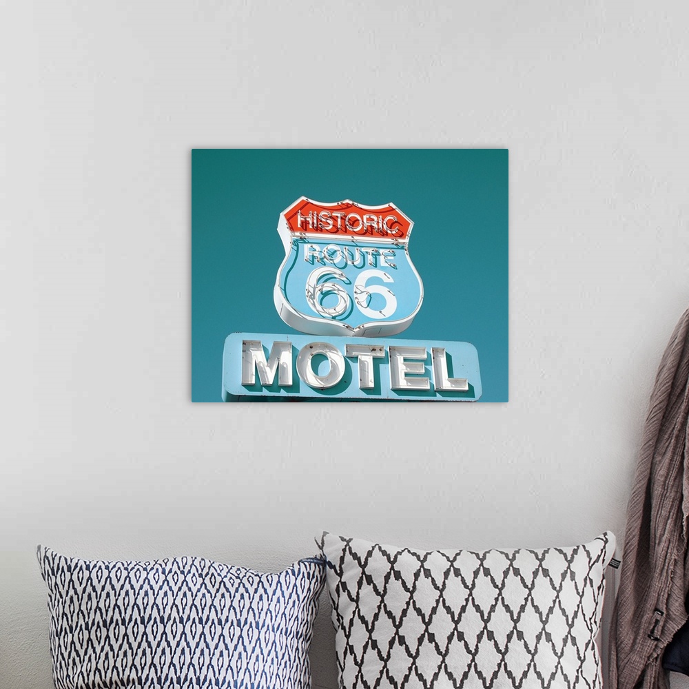 A bohemian room featuring Photograph of an antique Route 66 Motel sign on a clear blue sky background.