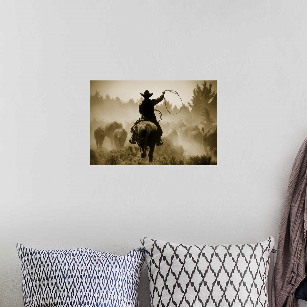 A bohemian room featuring A photo of a cowboy rounding up cattle in a dusty field.