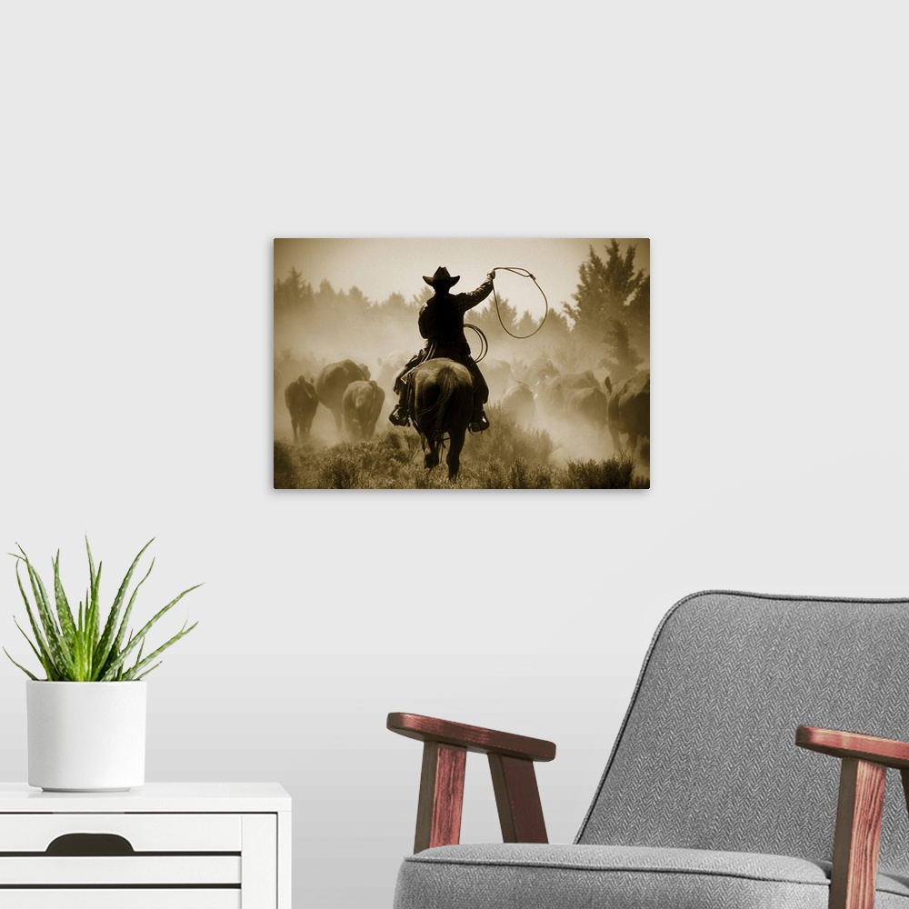 A modern room featuring A photo of a cowboy rounding up cattle in a dusty field.