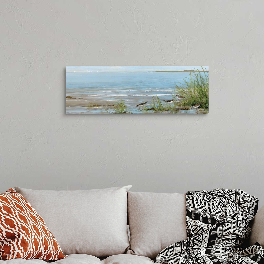 A bohemian room featuring A contemporary painting of a beach scene with birds foraging in the foreground and sailboats in t...