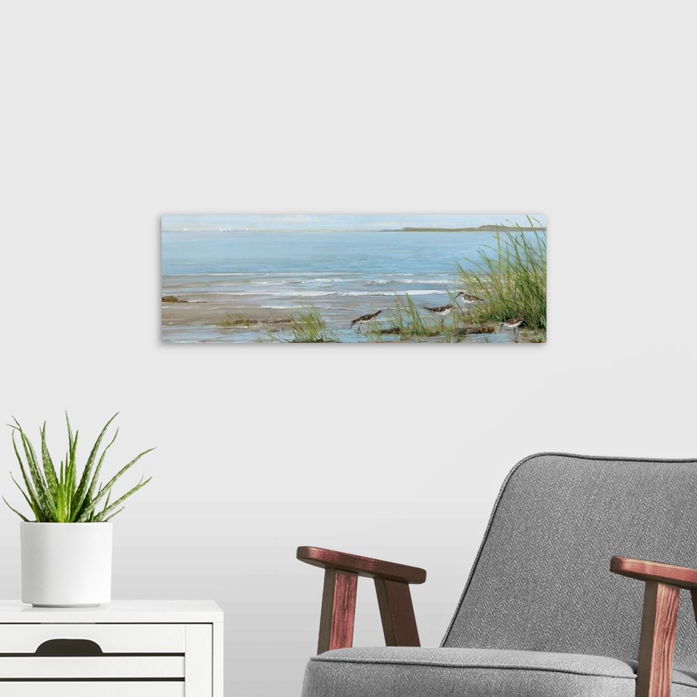 A modern room featuring A contemporary painting of a beach scene with birds foraging in the foreground and sailboats in t...