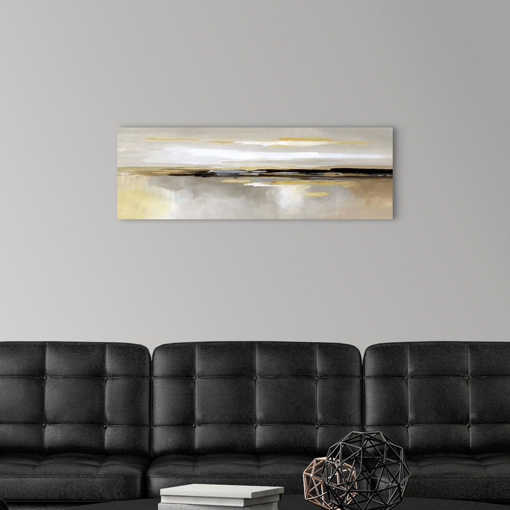 A modern room featuring Panoramic abstract painting of various shades of yellow, gray and white that accentuates a center...