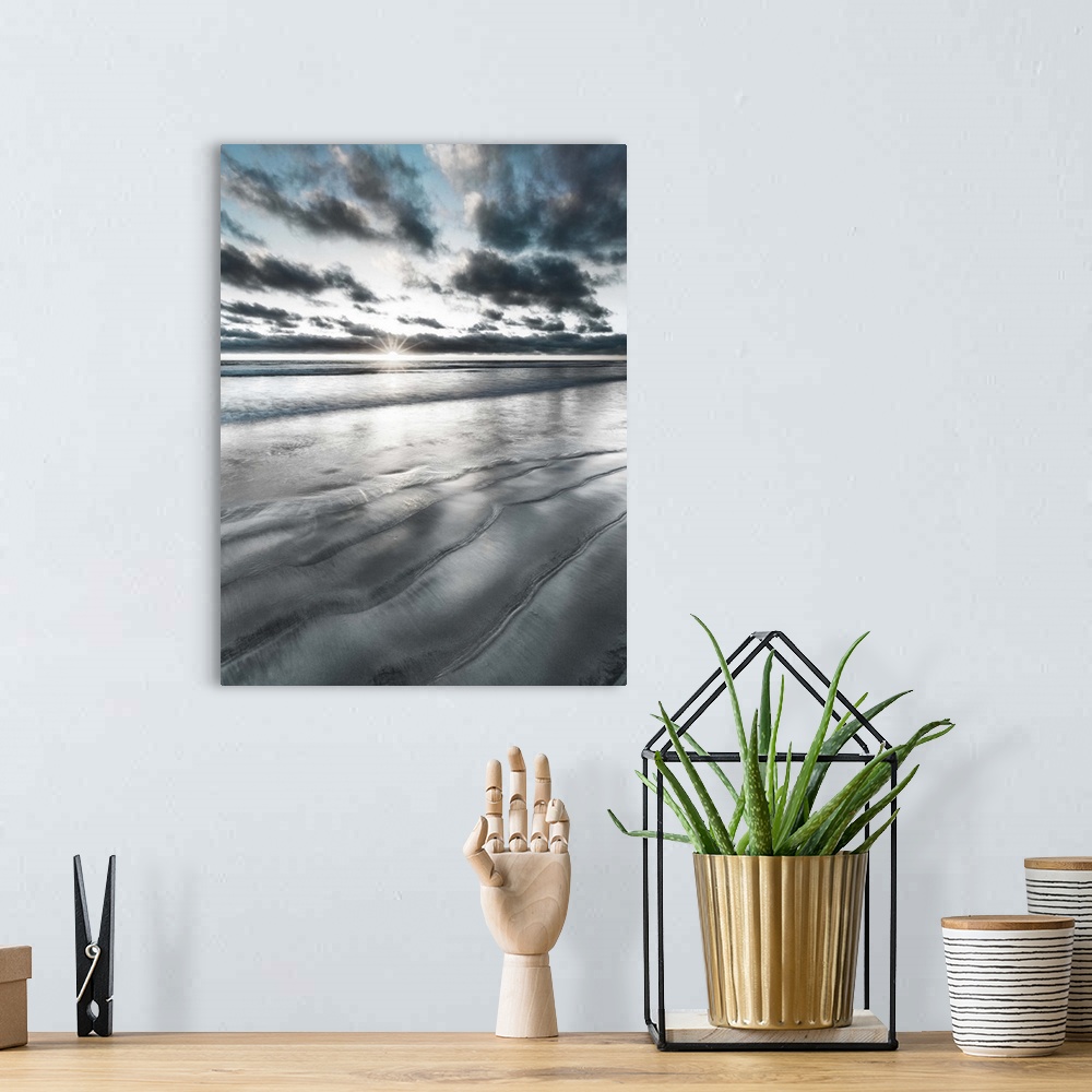 A bohemian room featuring Black, blue, and white manipulated photograph of a seascape with the sun right on the horizon line.