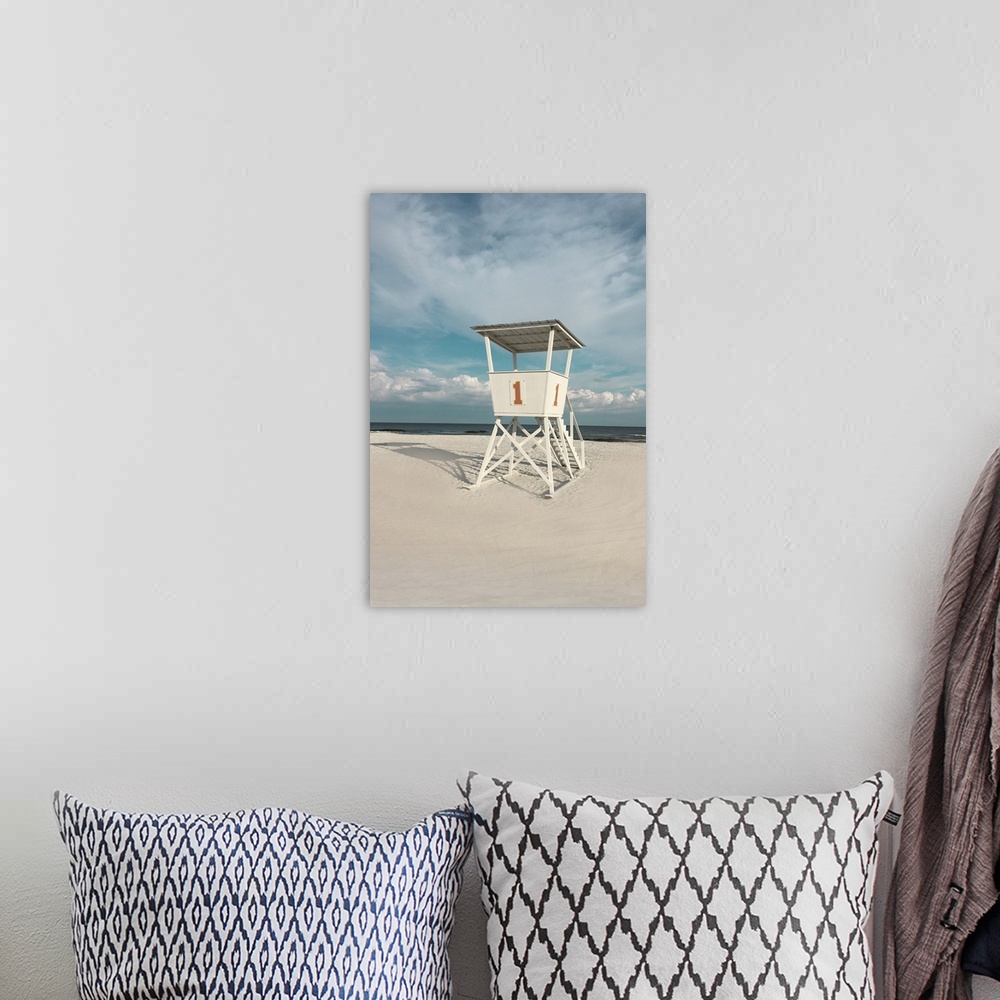 A bohemian room featuring A photo of a lifeguard tower on a cloudy day with an unoccupied beach in the background.