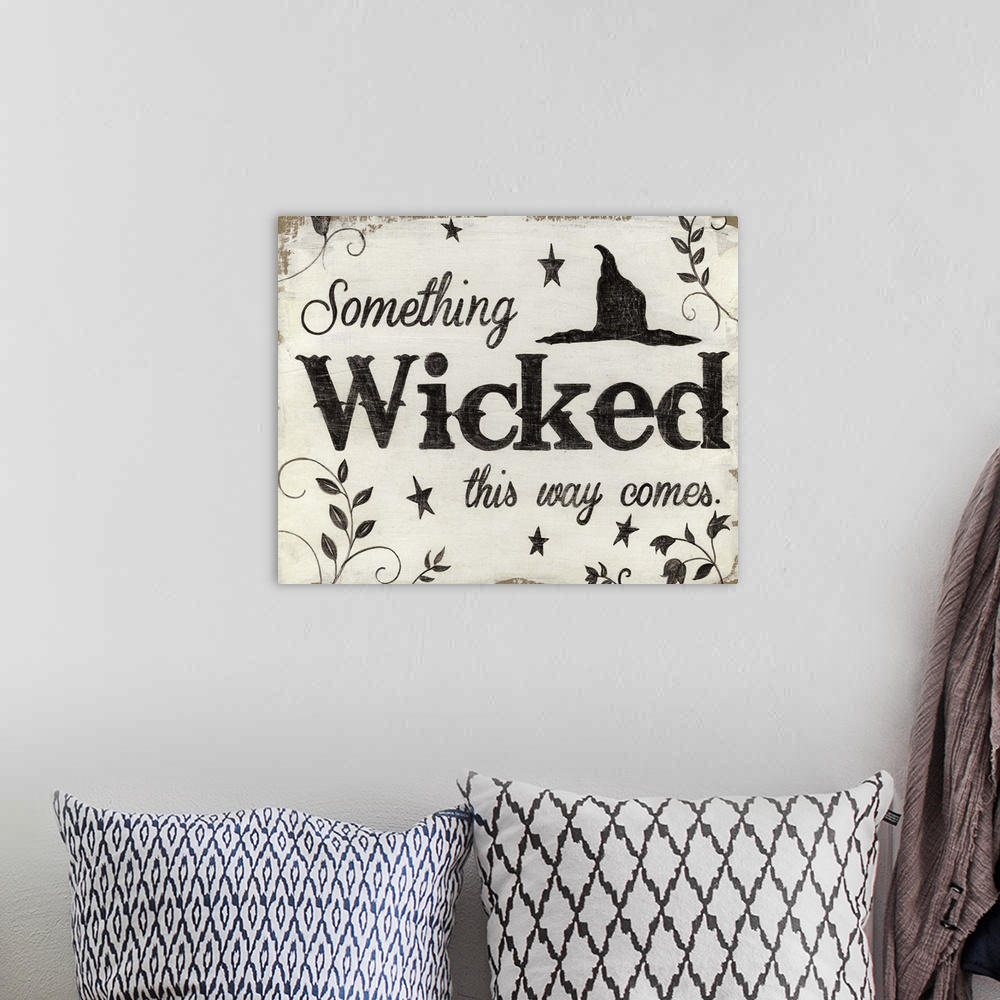 A bohemian room featuring A decorative Halloween painting that reads ?Something Wicked this way comes? on a white and tan b...