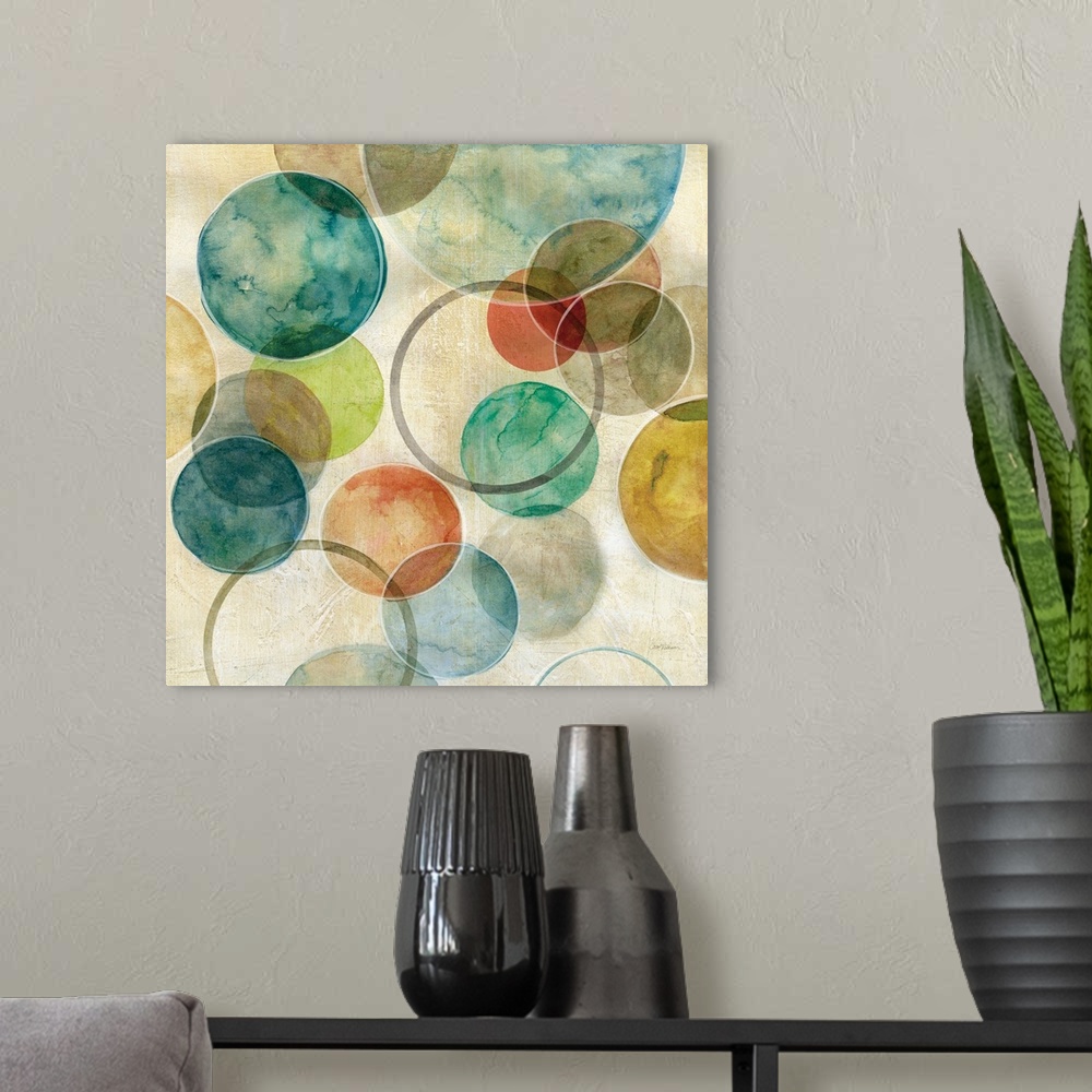 A modern room featuring A contemporary abstract painting of various colored circles on canvas.