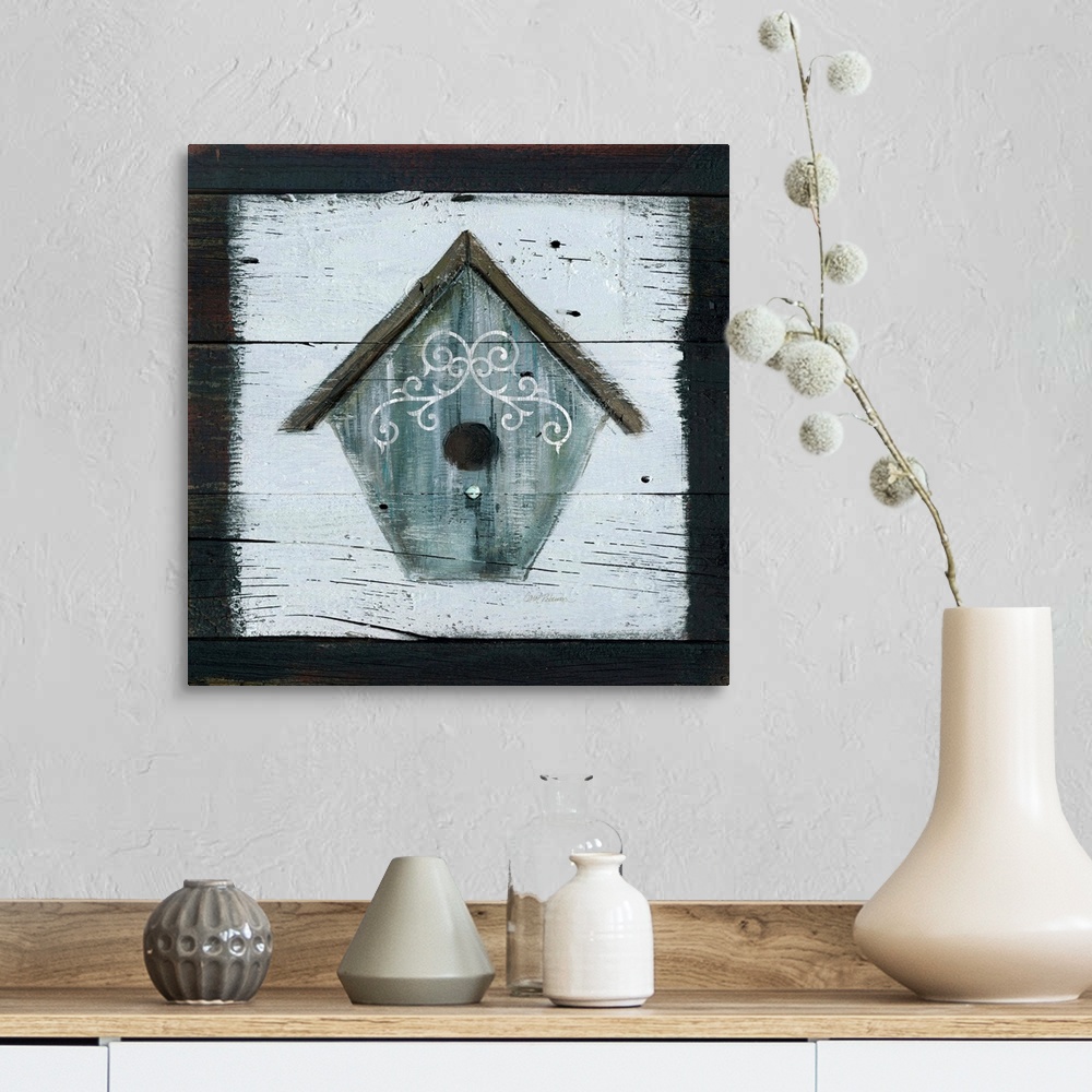 A farmhouse room featuring A wooden painting of a gray-blue bird house.