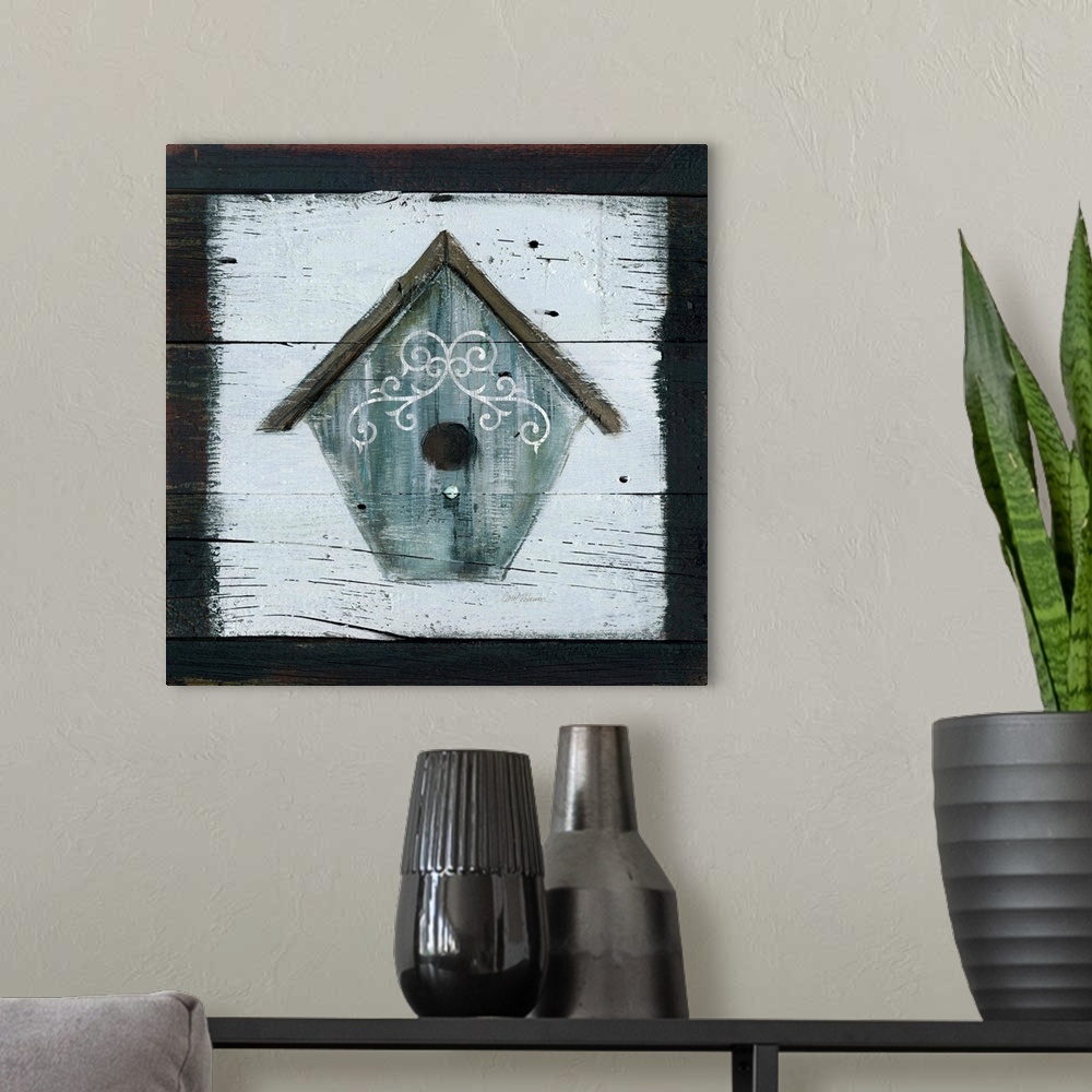 A modern room featuring A wooden painting of a gray-blue bird house.
