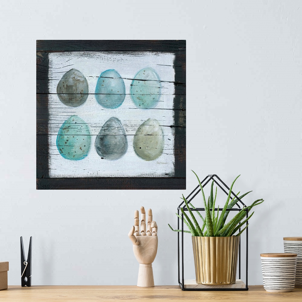 A bohemian room featuring A wooden painting of six eggs using cool tones.