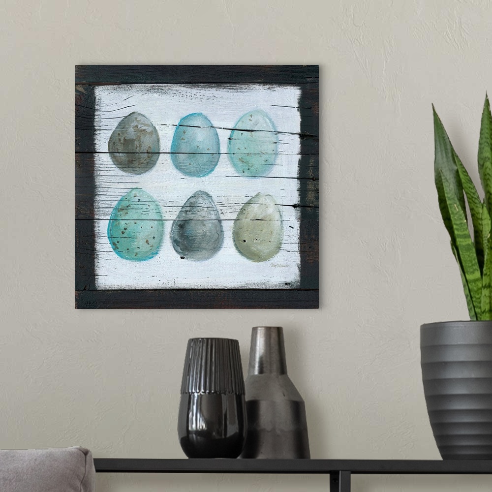 A modern room featuring A wooden painting of six eggs using cool tones.
