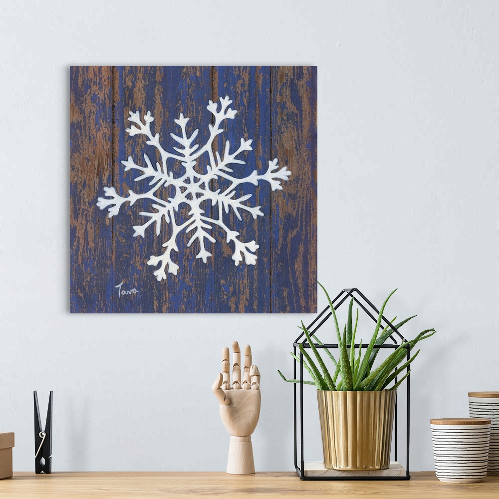 A bohemian room featuring A decorative painting of a white snowflake on a blue, aged wooden background.