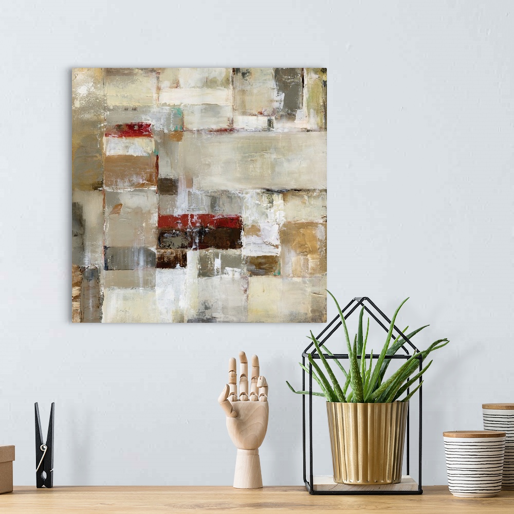 A bohemian room featuring A square abstract painting in natural shades of brown, beige and red.