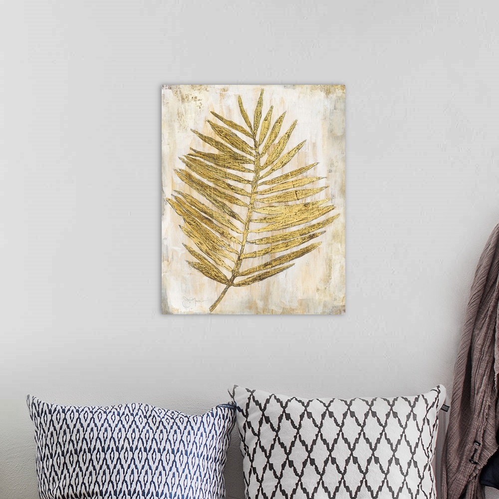 A bohemian room featuring Gold and cream decor with a palm branch that has thin leaves,