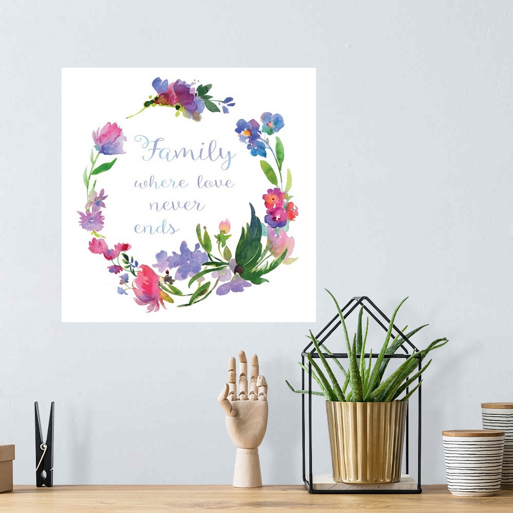 A bohemian room featuring "Family Where Love Never Ends" written in cursive inside of a watercolor floral wreath on a white...