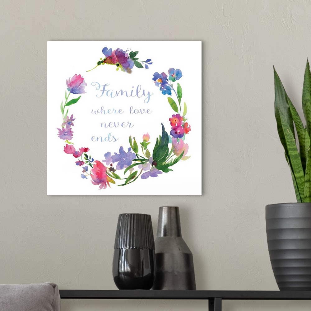 A modern room featuring "Family Where Love Never Ends" written in cursive inside of a watercolor floral wreath on a white...