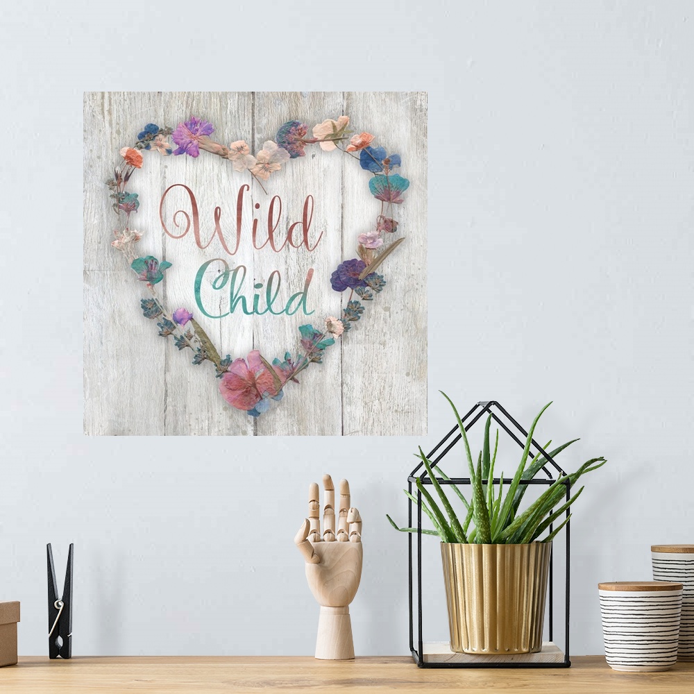 A bohemian room featuring "Wild Child" placed on a white washed wood texture with dried flowers surrounding it.