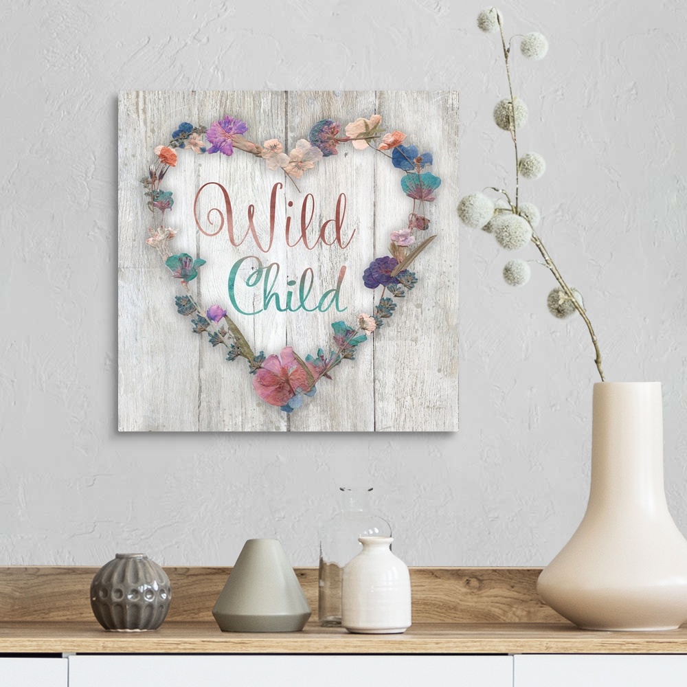 A farmhouse room featuring "Wild Child" placed on a white washed wood texture with dried flowers surrounding it.