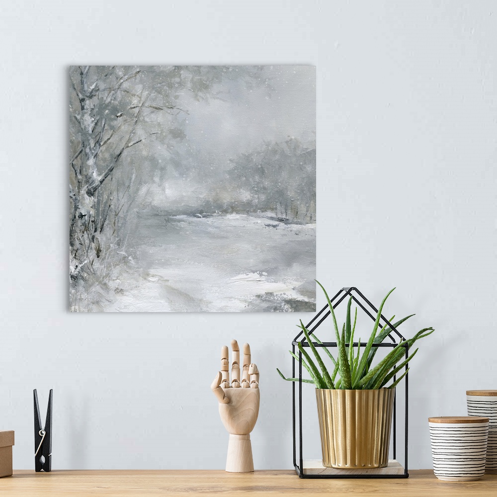 A bohemian room featuring A muted snow scene of a field outlined by a forest with snow falling.