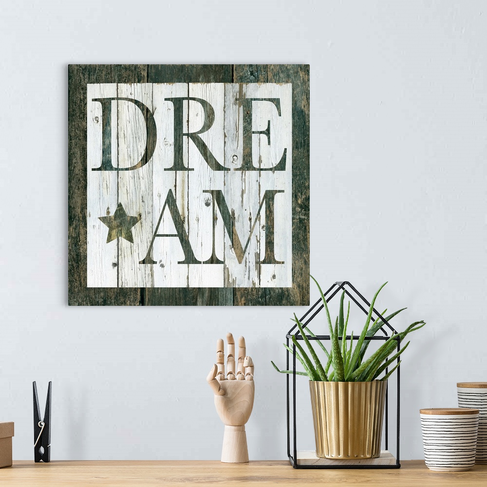 A bohemian room featuring Decorative artwork of a white square and the word 'Dream' in it against of rustic wood background.