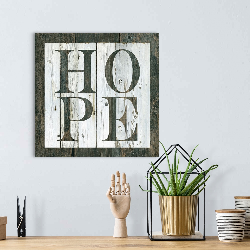 A bohemian room featuring Decorative artwork of a white square and the word 'Hope' in it against of rustic wood background.