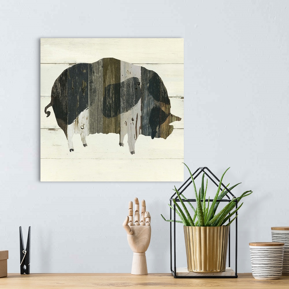 A bohemian room featuring A painting of a pig using multicolored stained wood placed on a white wooden background.