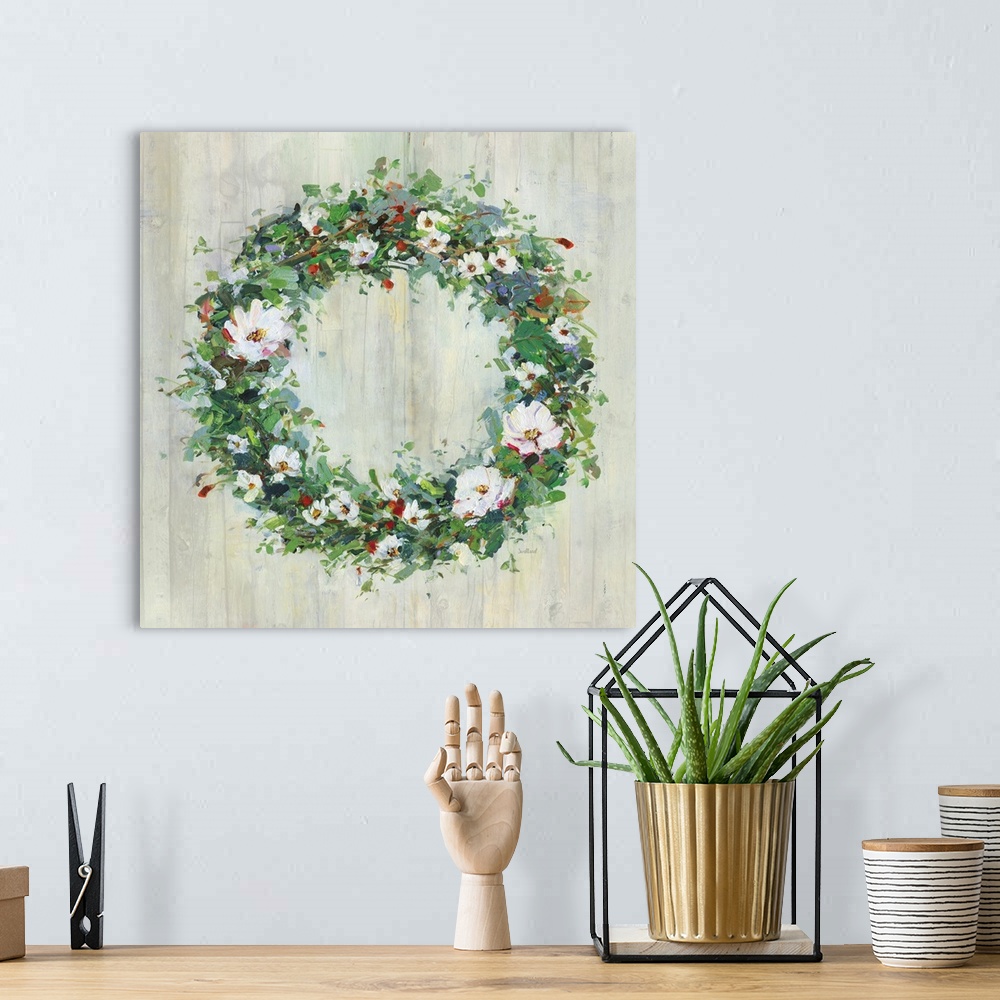 A bohemian room featuring A contemporary painting of a green wreath covered in white and red flowers on a wood background.