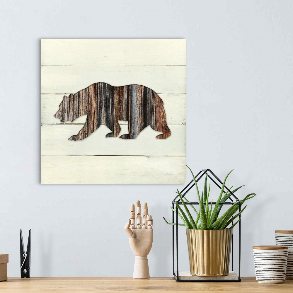 A bohemian room featuring Square decor of a dark brown wooden silhouette of a bear on a white wooden plant background.