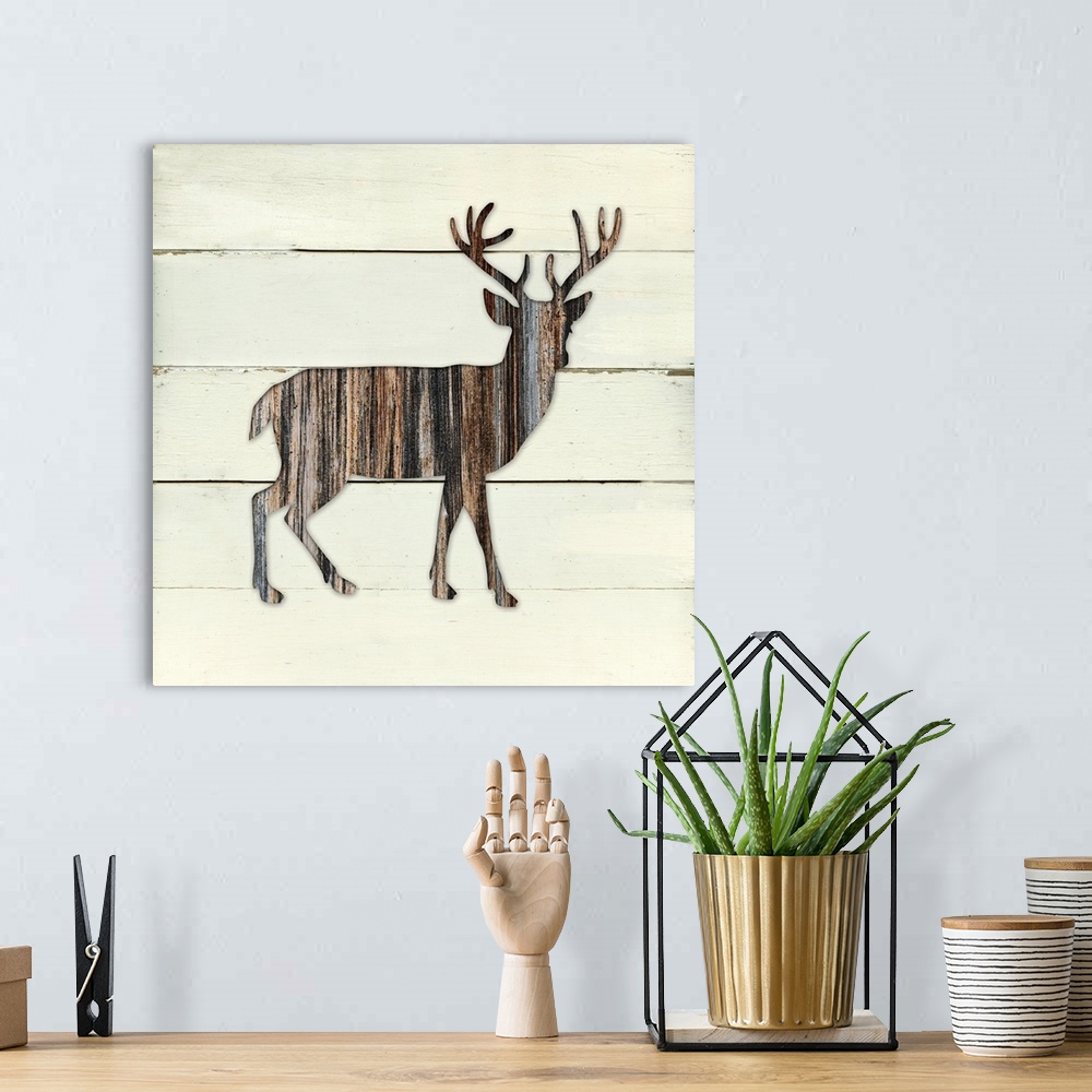 A bohemian room featuring Square decor of a dark brown wooden silhouette of a deer on a white wooden plant background.