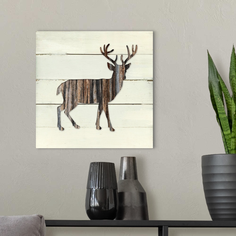 A modern room featuring Square decor of a dark brown wooden silhouette of a deer on a white wooden plant background.