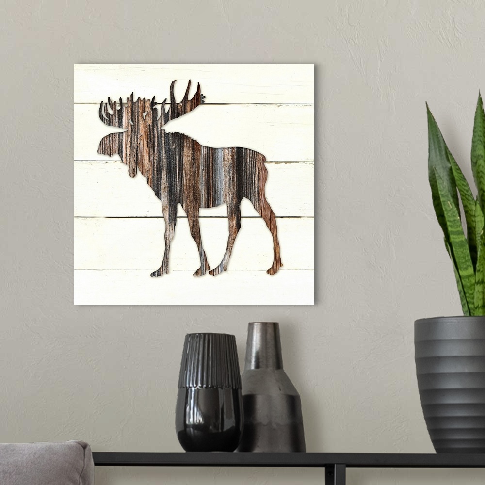 A modern room featuring Square decor of a dark brown wooden silhouette of a moose on a white wooden plant background.