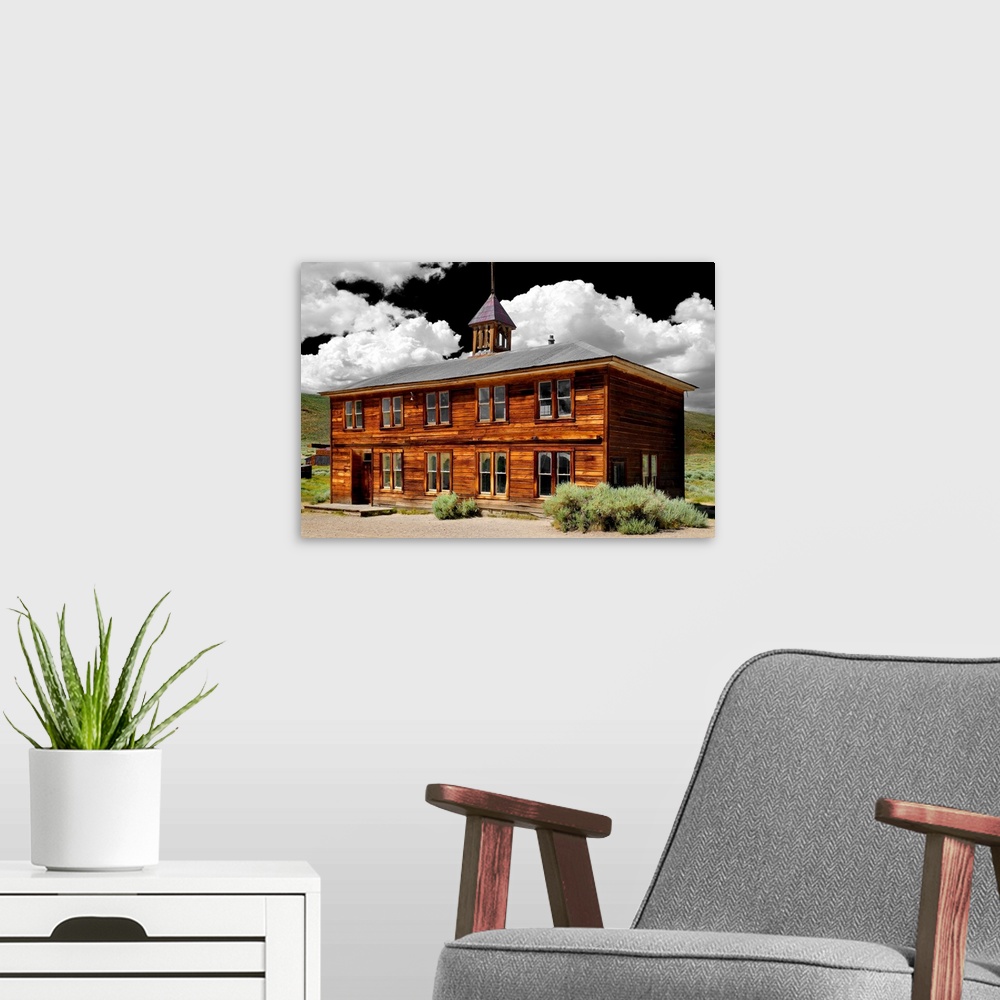 A modern room featuring Dramatic photograph of an abandoned schoolhouse with a black sky and white fluffy clouds above.