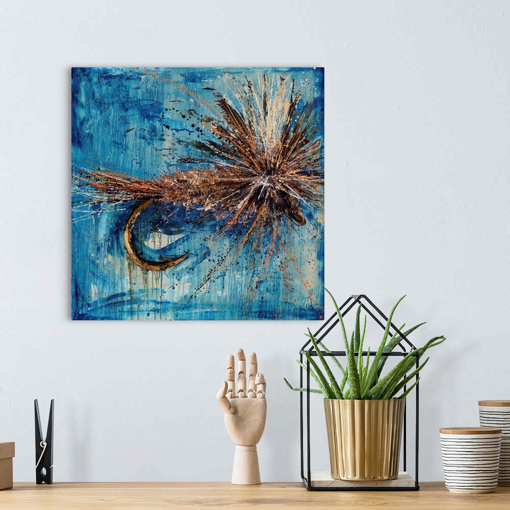 A bohemian room featuring Square painting of an orange, brown, and tan fly fishing lure on a blue background.