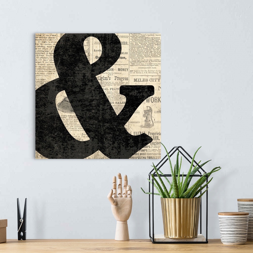 A bohemian room featuring Square decor with a large black ampersand on a newspaper background.