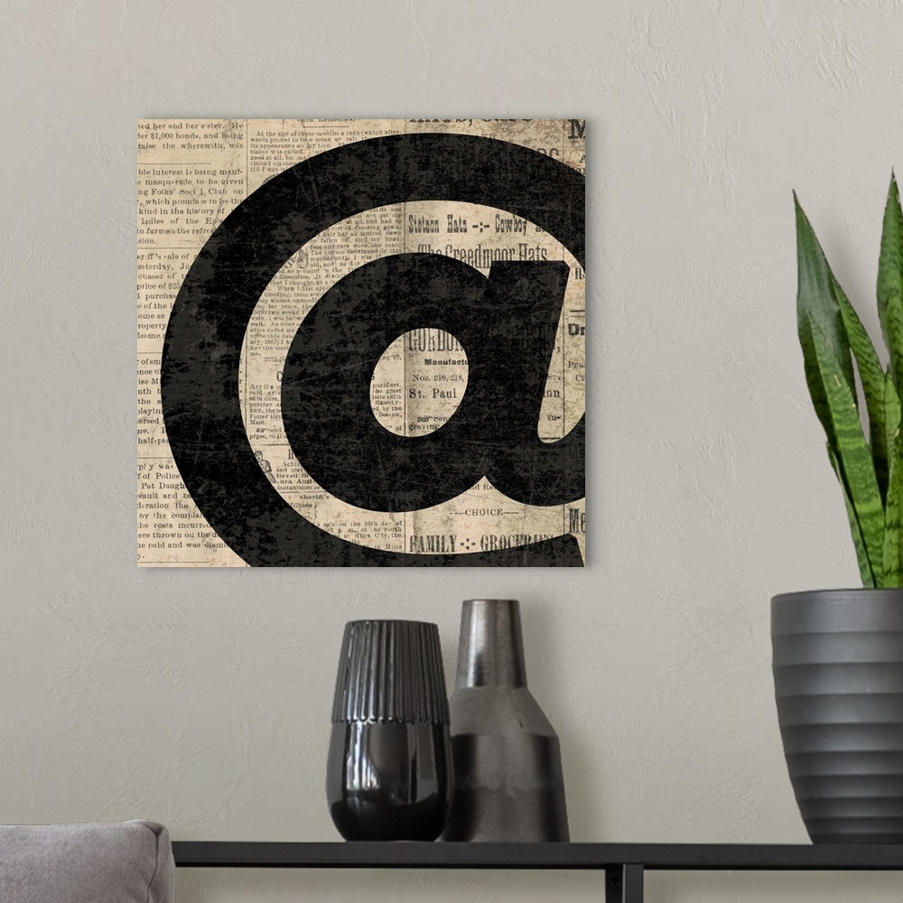 A modern room featuring Square decor with a large black "at" symbol on a newspaper background.