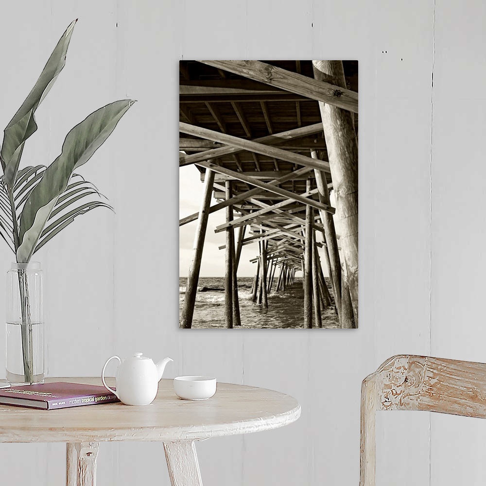 A farmhouse room featuring Big monochromatic photograph taken from beneath a large wooden pier examines the foundation of it...