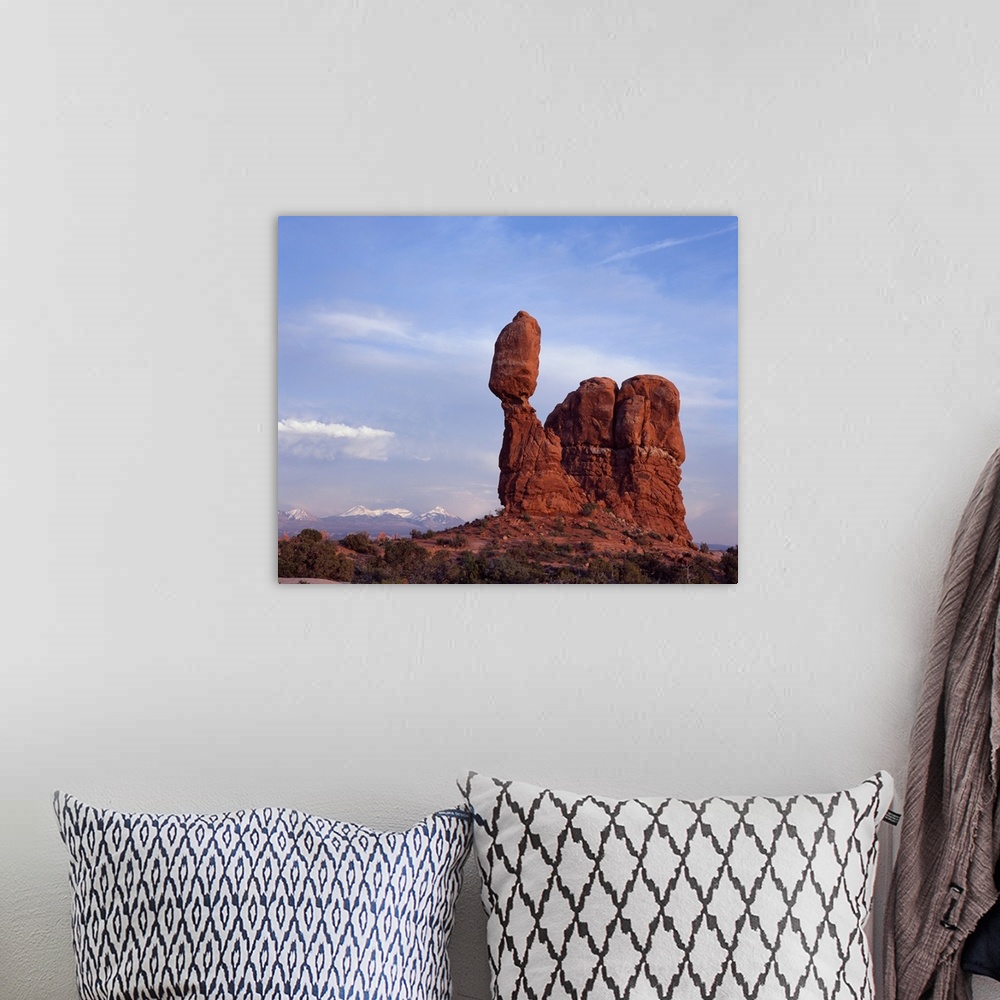 A bohemian room featuring Landscape photograph of Balancing Rock in Utah with snow capped mountains in the distance.