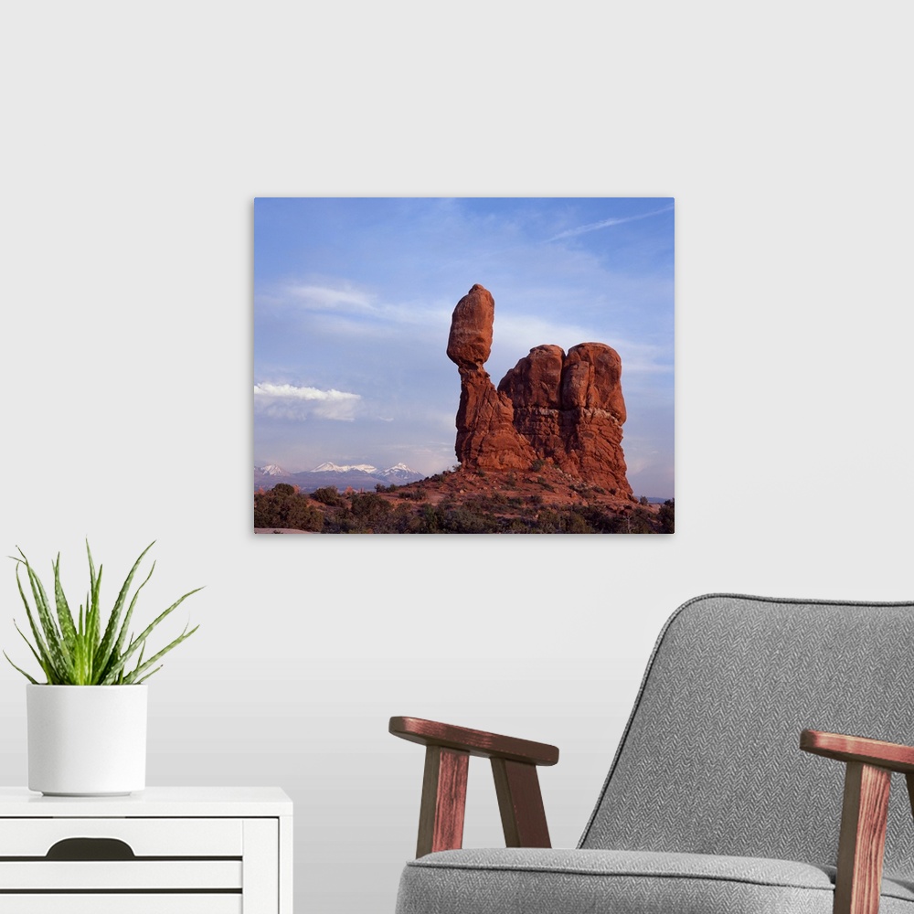 A modern room featuring Landscape photograph of Balancing Rock in Utah with snow capped mountains in the distance.