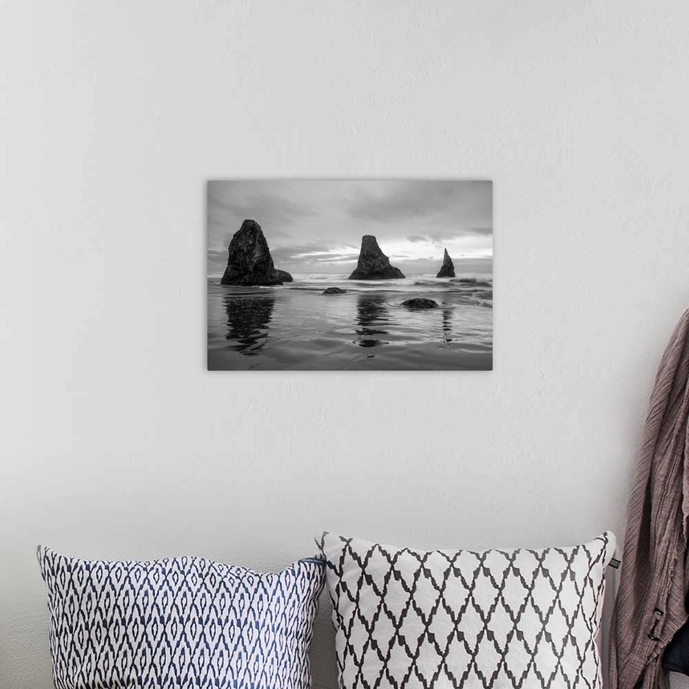 A bohemian room featuring Black and white photograph of the Pacific Ocean with three rock formations near the shore in Band...