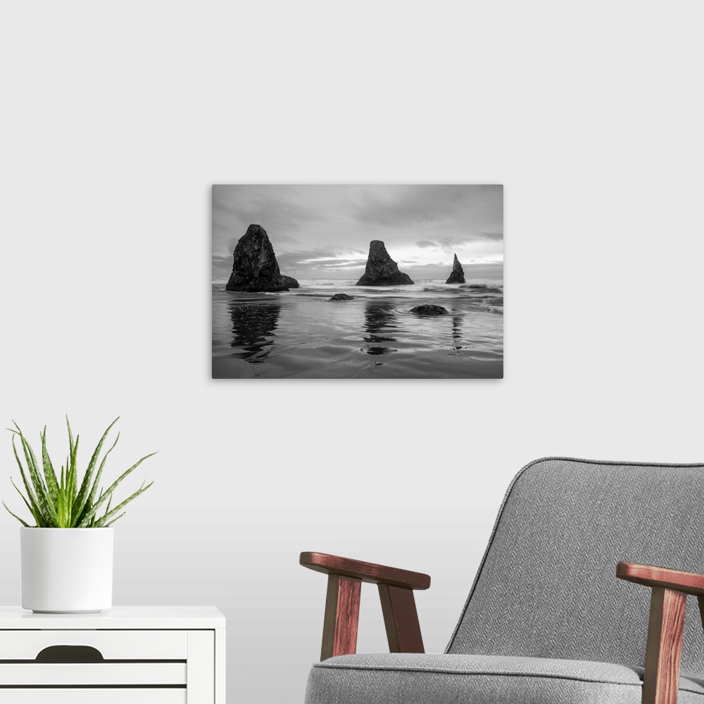 A modern room featuring Black and white photograph of the Pacific Ocean with three rock formations near the shore in Band...